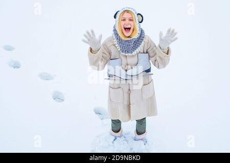 Winter game. Beautiful woman enjoying first snow. Portrait of a happy teenage girl in the snow. Winter young woman portrait. Happy young woman walking Stock Photo