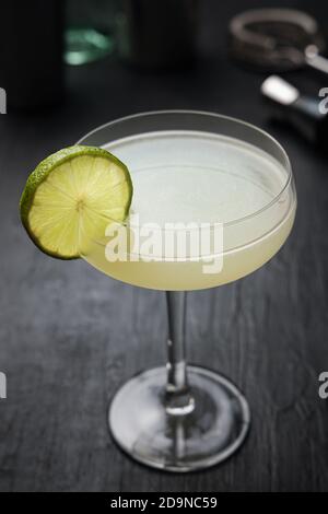 Classic Daiquiri Cocktail with a lime wheel on a black table Stock Photo