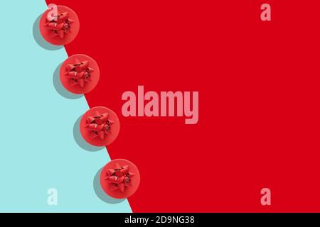 Pattern of red gift boxes with decorative bow on blue and red surface, flat lay, copy space. Holiday concept new year or Christmas gift box presents Stock Photo
