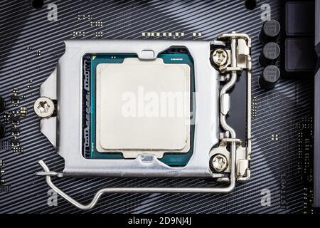 Closeup detail of CPU Chip over socket of a modern computer black motherboard. Electronic small component details. Select focus Stock Photo