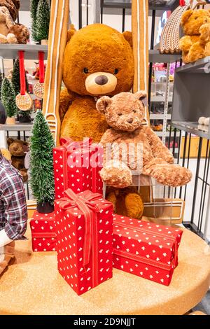 A big teddy bear and a red gift box placed on the floor as a Christmas present. Stock Photo