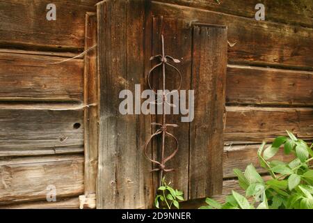 Facade of an old cabin in Romania's countryside. Boarded up windows. Stock Photo