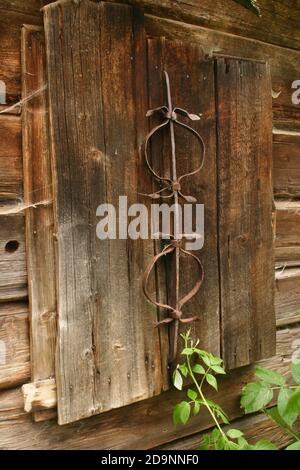 Facade of an old cabin in Romania's countryside. Boarded up windows. Stock Photo