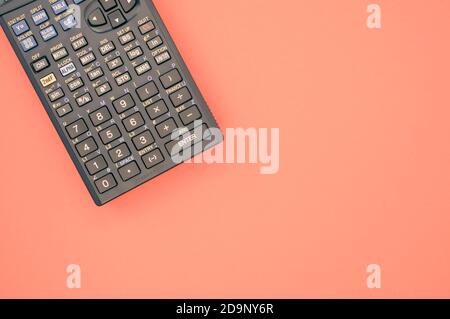 A top view closeup of a graphing calculator isolated on a bright pink background Stock Photo