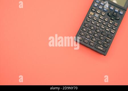 A top view closeup of a graphing calculator isolated on a bright pink background Stock Photo