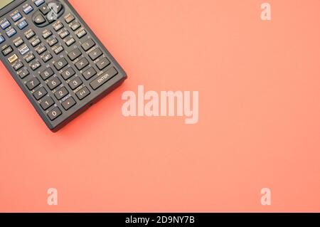 A top view closeup of a graphing calculator isolated on a bright pink background Stock Photo