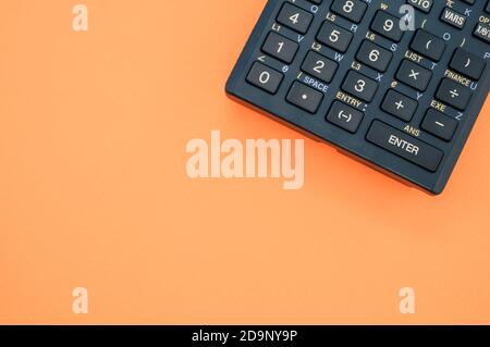 A top view closeup of a graphing calculator isolated on an orange background Stock Photo