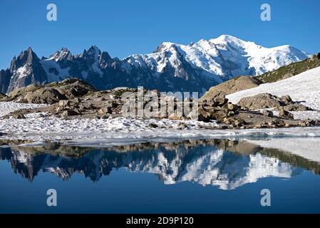 France, Haute-Savoie, Alps, Mont Blanc mountain range with Aiguilles de Chamonix (left), Aiguille du midi (3842m), Mont blanc du Tacul (4248m midden), Mont Maudit (4465m), Mont Blanc (4810m) and Aiguille de Bionnassay (4052m right) reflecting in Lac Blanc (2350m) Stock Photo