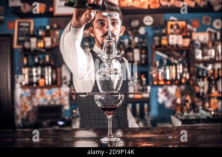 Expert bartender mixes a cocktail in pub Stock Photo