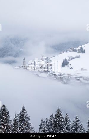 the villages of candid and casamazzagno emerging from the winter mists, dolomites, comelico superiore, belluno, veneto, italy, europe Stock Photo