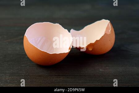 Closeup of cracked eggshells isolated on black wooden table Stock Photo