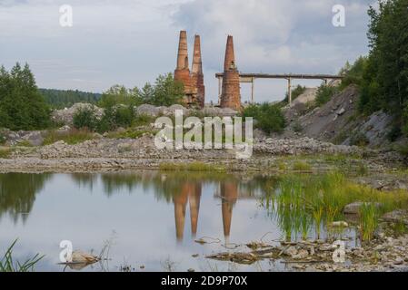 A view of the ruins of an abandoned marble and lime factory in the August evening. Ruskeala, Karelia Stock Photo