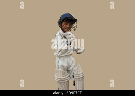 Boy in cricket uniform A victorious standing in front Stock Photo