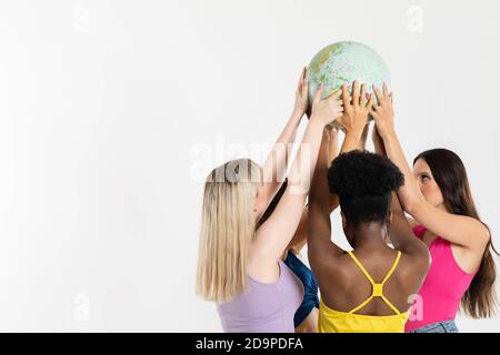 A large globe with all continents is supported by female hands of various races, symbolizing unity, acceptance and racial tolerance. Stock Photo