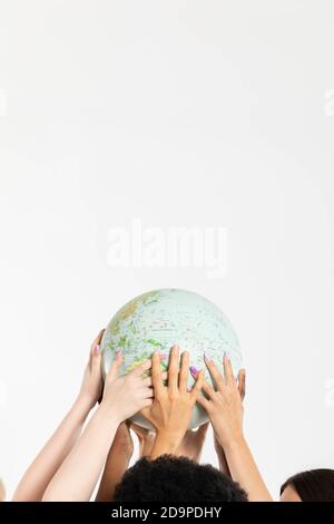 A large globe with all continents is supported by female hands of various races, symbolizing unity, acceptance and racial tolerance. Stock Photo