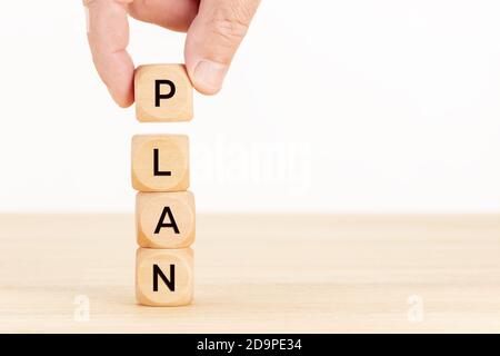 Plan concept. Hand holding a Wooden block with text on table. Copy space Stock Photo