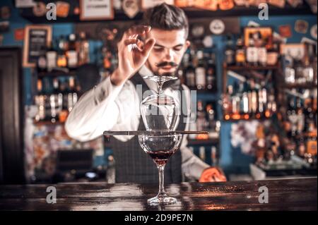 Charismatic Female bartender is pouring a drink in the nightclub Stock Photo