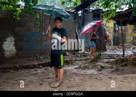 San Pedro Sula, Honduras. 06th Nov, 2020. Children use umbrellas during a rain storm in San Pedro Sula.Three days after Hurricane Eta hit the Nicaraguan coast as a Category 4 storm, the aftermath of flooding and mudslides has displaced over 350,000 Hondurans. The death toll in Central America is over 100 and expected to rise because of many missing people Credit: SOPA Images Limited/Alamy Live News Stock Photo