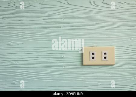 Wall outlets on the pale green wall with wood texture. Stock Photo