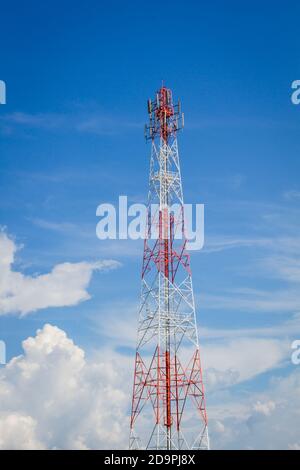 telecommunication tower in the middle of the picture with cloudy blue sky, vertical frame. Stock Photo