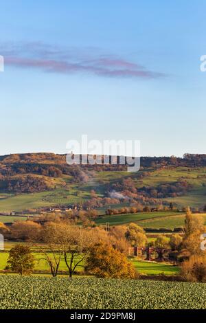 A late afternoon autumn view across fields to Bredon hill tower and Eckington bridge over the Avon river, Worcestershire, England Stock Photo