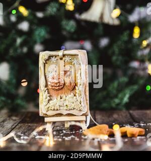 Hand painted Christmas gingerbread on a wooden stand with abstract bokeh background. Close-up. Stock Photo