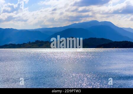 Sunlight reflecting off water waves to cause sun glitter at Umiam lake, also known as Barapani lake, on the outskirts of Shillong, Meghalaya, India. Stock Photo