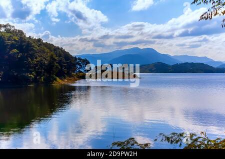 The calm waters of Umiam lake on a winter afternoon. The lake also known as Barapani lake is situated on the outskirts of Shillong, Meghalaya, India. Stock Photo