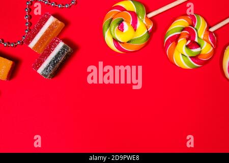 Candy, lollipops, multi-colored marmalade on a red background with a place for text layout Stock Photo