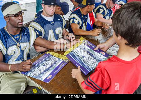 Miami Florida,Little Havana,Calle Ocho Festival,annual event FIU football players signing autographs,Black African man male student, Stock Photo