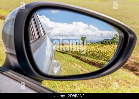 View of the countryside and mountains from the side mirror of a car, Bientina, Tuscany, Italy Stock Photo