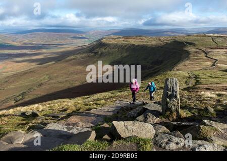 Walkers Heading Towards the Summit of Ingleborough with the View Towards Ribblehead and Simon Fell, Yorkshire Dales, UK Stock Photo
