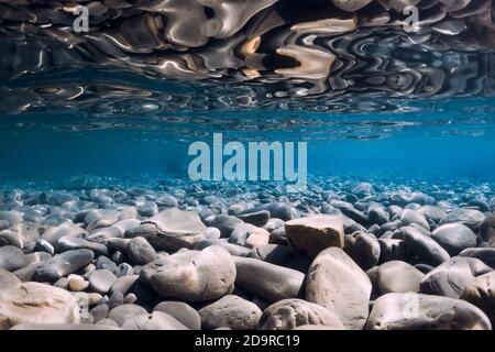 Underwater sea with stones, reflection and blue water. Stock Photo