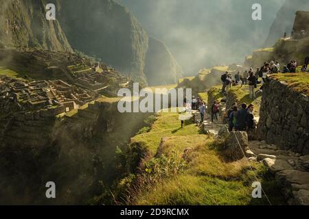 Queues of tourists exploring the ruins of Machu Picchu, Peru Stock Photo