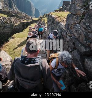 Queues of tourists exploring the ruins of Machu Picchu, Peru Stock Photo