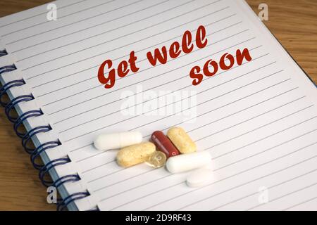 English text 'Get well soon' inspired by the worldwide Coronavirus pandemics. The text is written on lined paper. Stock Photo