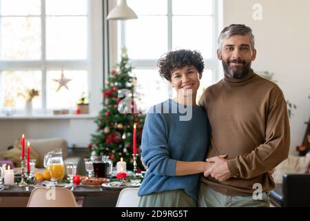 Young cheerful and affectionate couple in casualwear looking at you with smiles Stock Photo