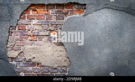 Rustic red corroded brick hole in a grey plaster wall. High quality texture and background for your projects and creative work Stock Photo