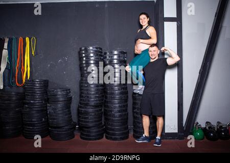 Athletes pregnant woman and her husband posing in the gym near the sports  equipment. Active sports pregnancy. Workout in the gym together during  Stock Photo - Alamy