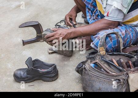 Traditional cobbler repairing shoes in 