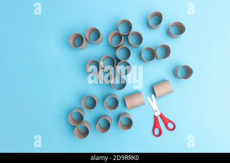 cut rolls from toilet paper, how to make advent calendar, crafts for children, DIY, step 1, top view, blue background Stock Photo