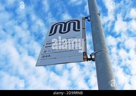 Bus stop sign uk on a pole with a blue sky and clouds in Manchester, England Stock Photo