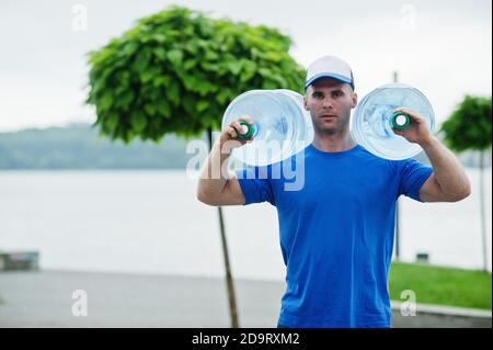 Delivery man carrying water bottle on shoulder. Stock Photo