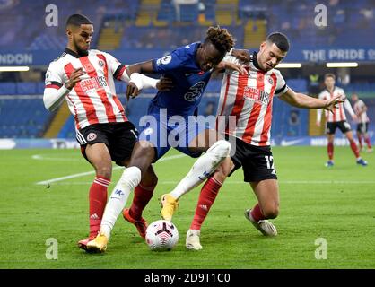 Chelsea's Tammy Abraham (centre) battles for the ball with Sheffield United's Max Lowe (left) and John Egan during the Premier League match at Stamford Bridge, London. Stock Photo