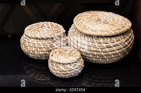 Three round wisker casket made of seaweed on a dark background. Stock Photo