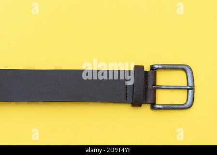 Part of leather belt on yellow background, top view. Casual style Stock Photo