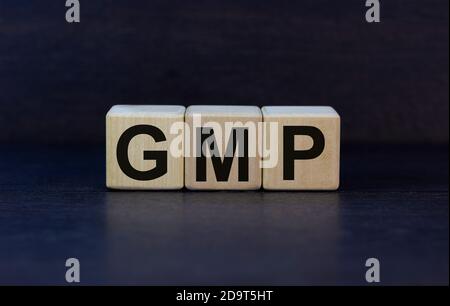 Concept word 'GMP, good manufacturing practice' on cubes on a beautiful dark wooden background. Business concept. Copy space. Stock Photo