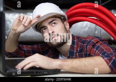 professional cctv technician working in the ceiling Stock Photo