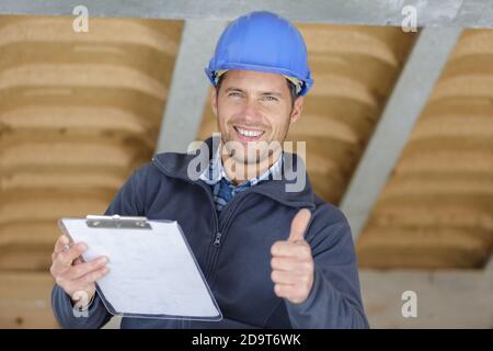 optimistic worker builder man posing showing thumb up Stock Photo