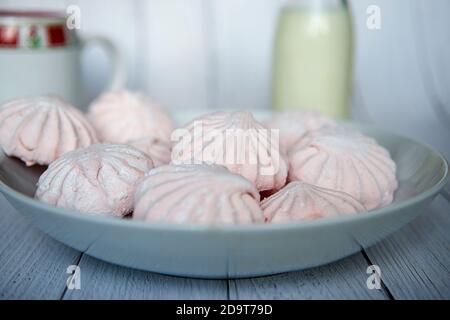 Pink marshmallows on a white plate. White and pink sweet homemade marshmallows or zephyr. Side view. Selective focus. Stock Photo